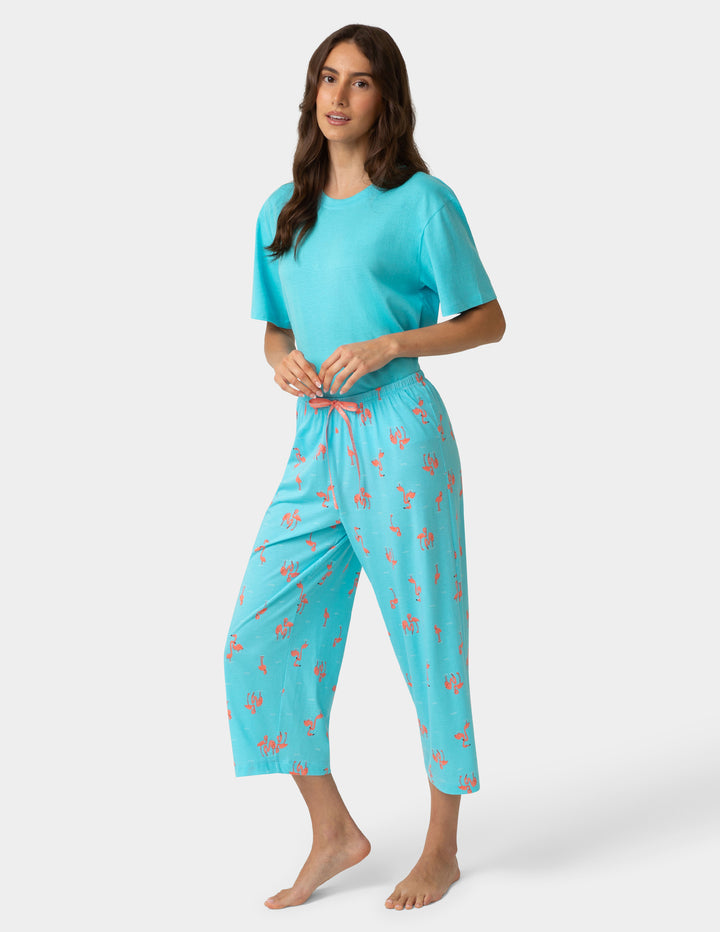 Woman wearing a turquoise pajama set with a white background