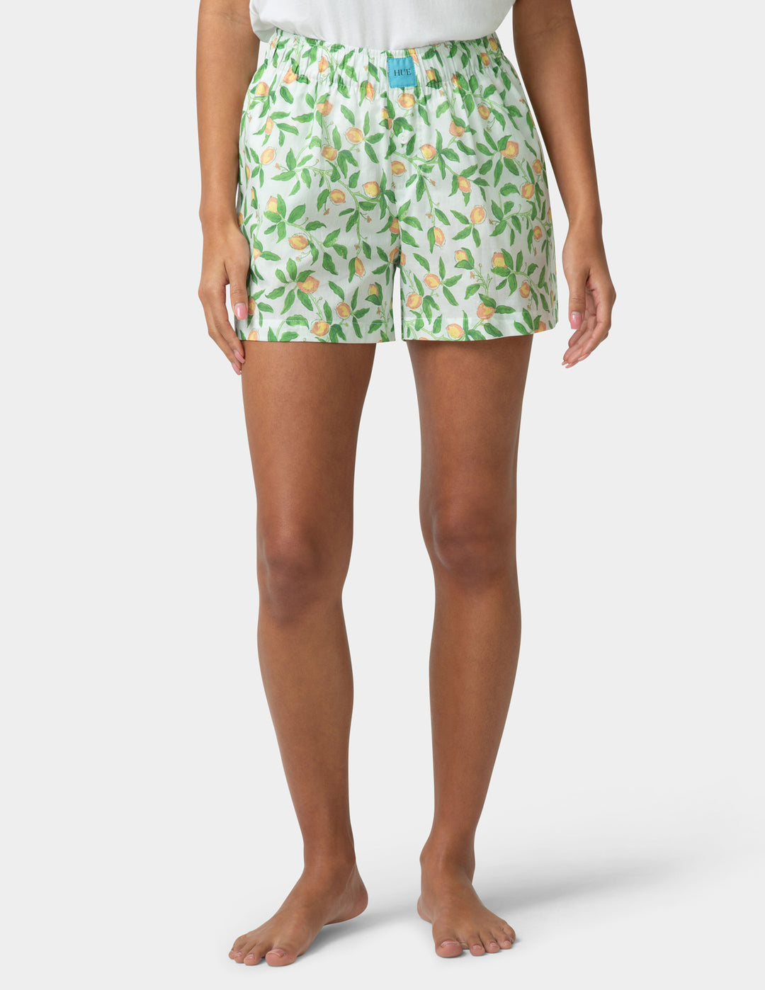 Person wearing green floral pj boxers on a white background