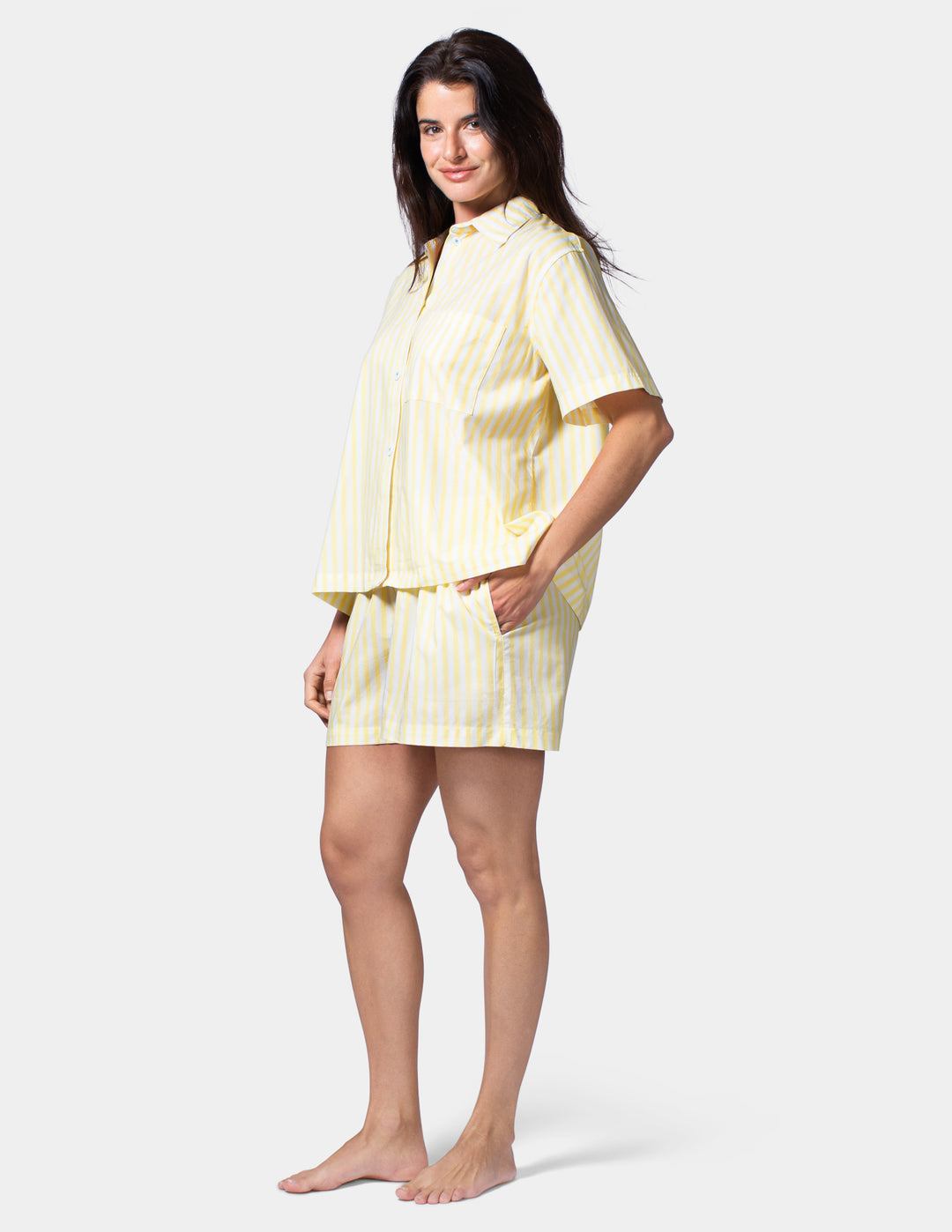 Woman wearing a yellow striped pajama set on a white background