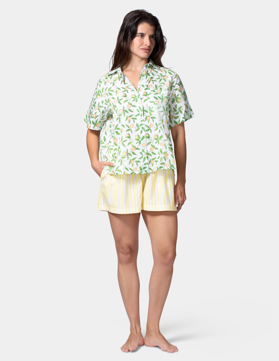 Woman wearing a lemon shirt and yellow shorts on a white background
