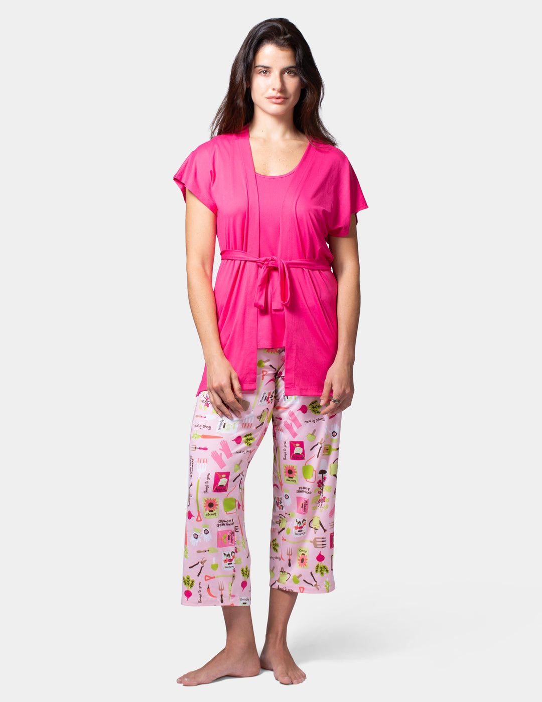 Woman wearing a pink top and patterned pants on a white background