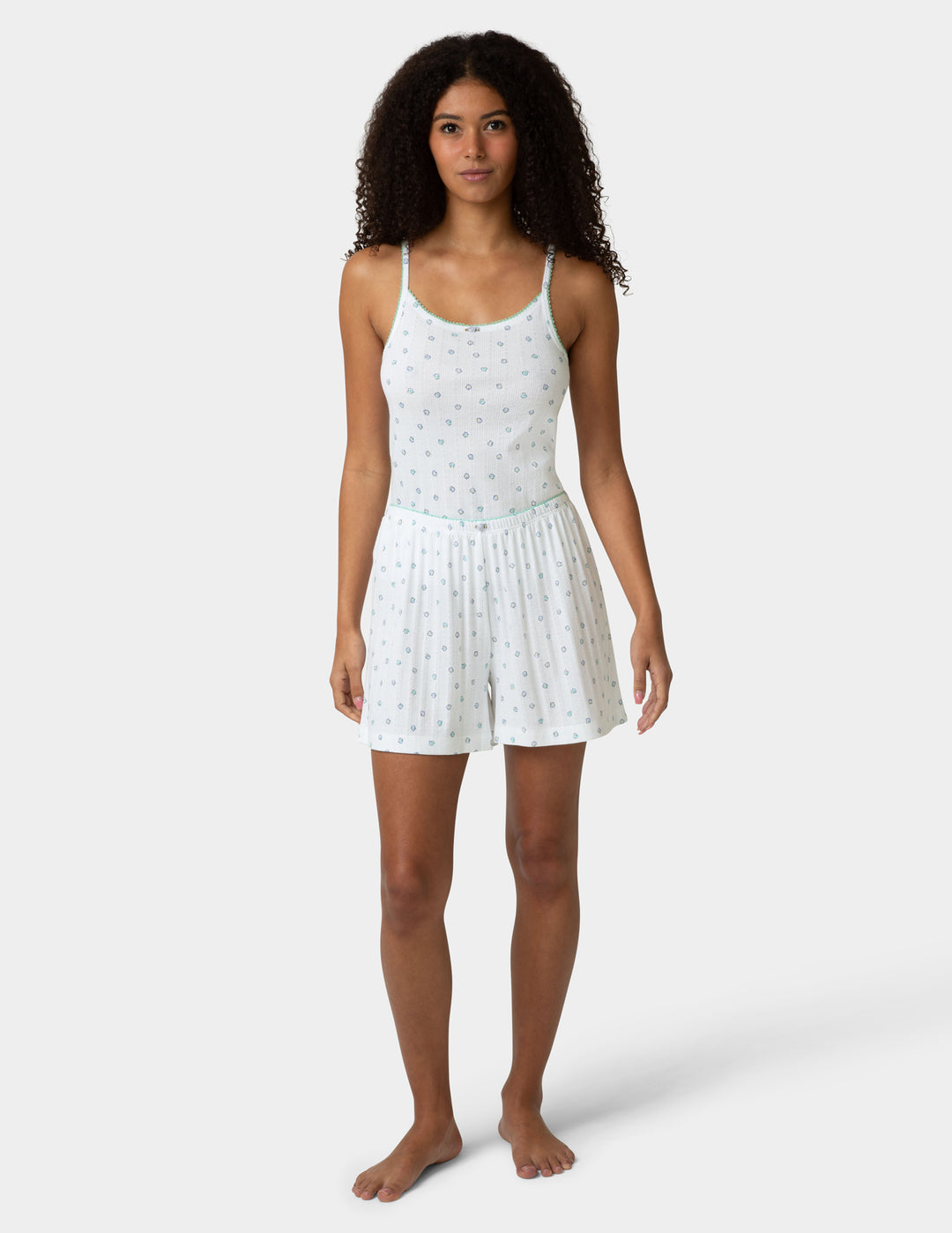 White pointelle PJ set being worn by a woman on a white a background 