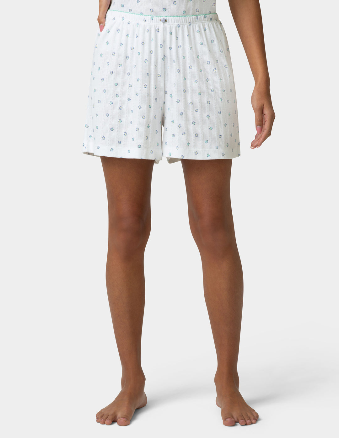 White pointelle PJ boxers being worn by a woman on a white a background 