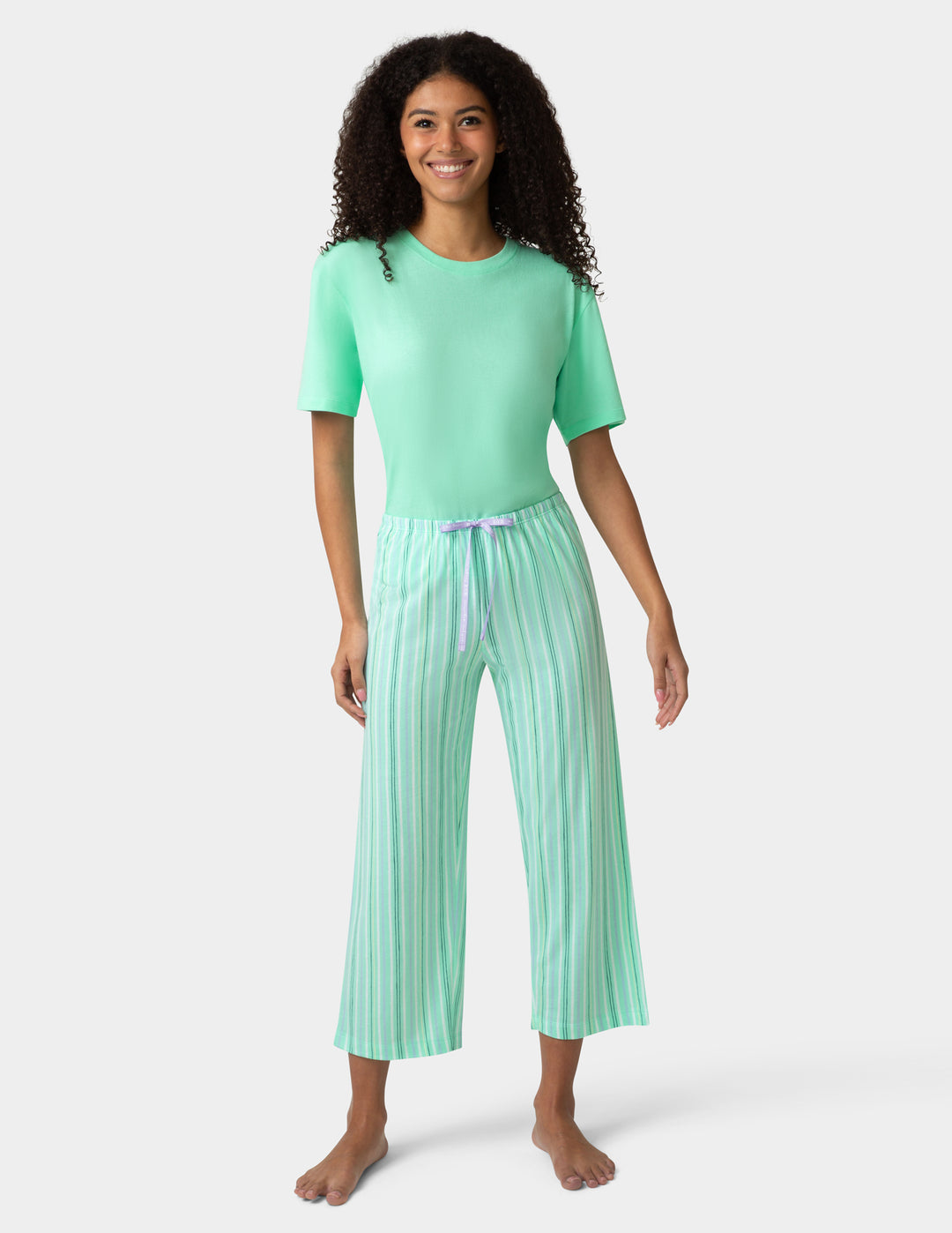 Woman wearing a green pajama set with a white background