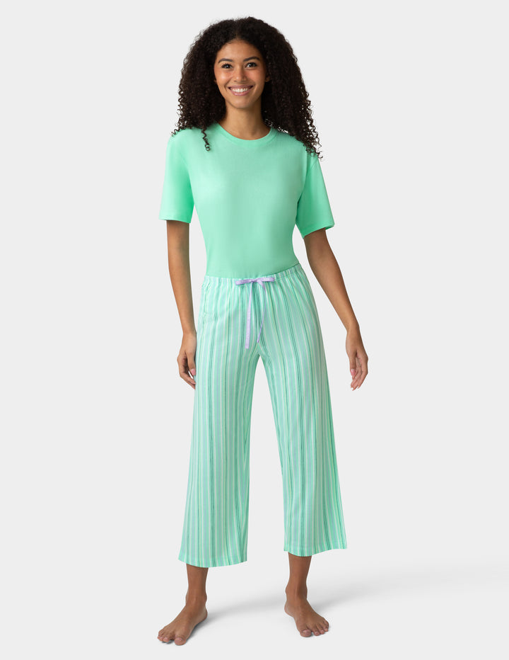 Woman wearing a green pajama set with a white background