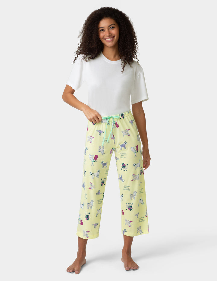 Woman wearing a white t-shirt and yellow patterned pants on a white background