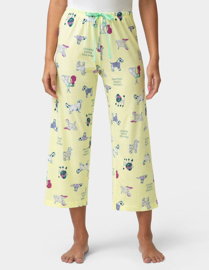 Yellow pajama pants with dog pattern worn by a person on a white background