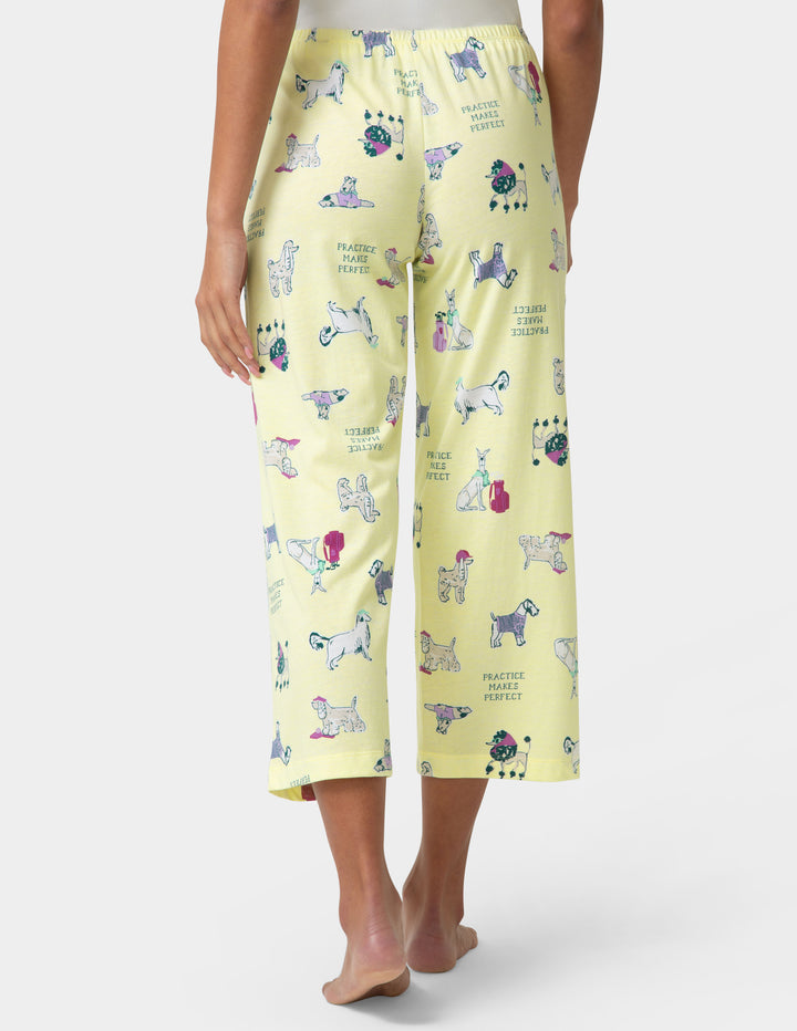 Person wearing yellow pajama pants with dog print on a white background
