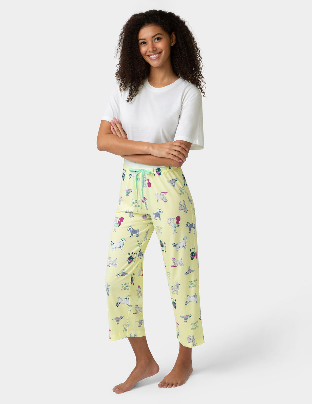 Woman wearing a white t-shirt and yellow patterned pants on a white background