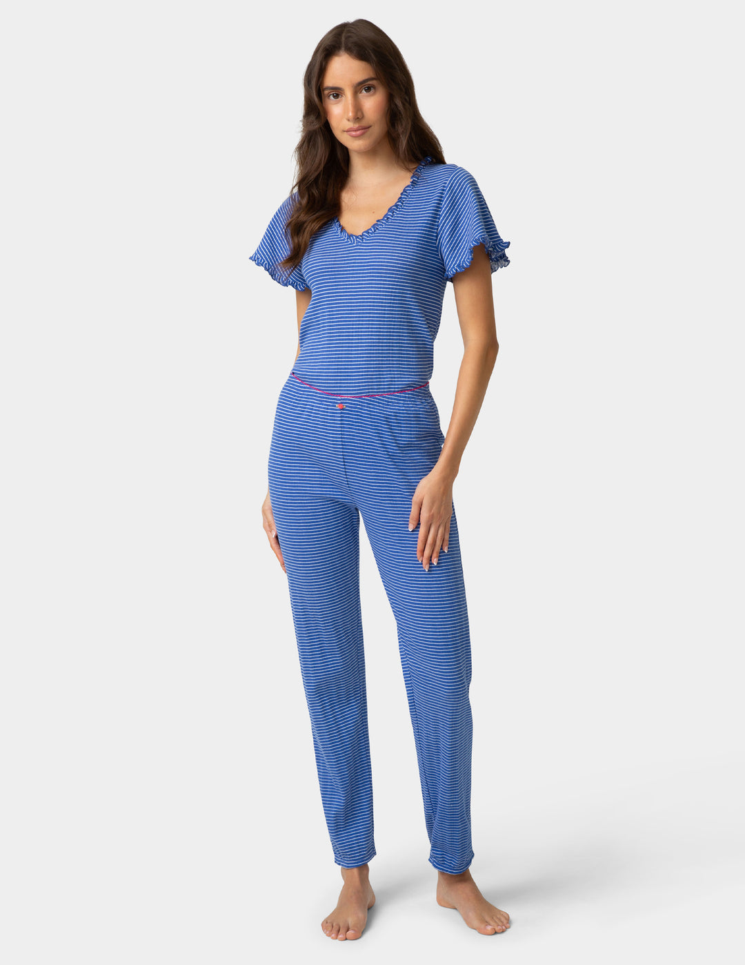 Woman wearing a blue striped pajama jogger and tee on a white background