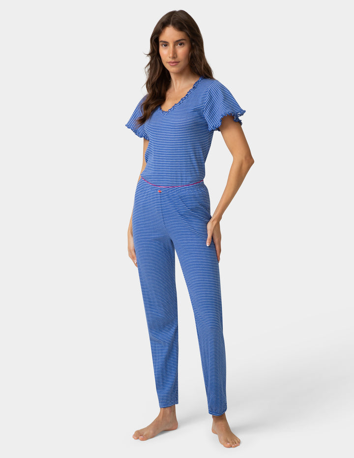Woman wearing a blue striped pajama set on a white background
