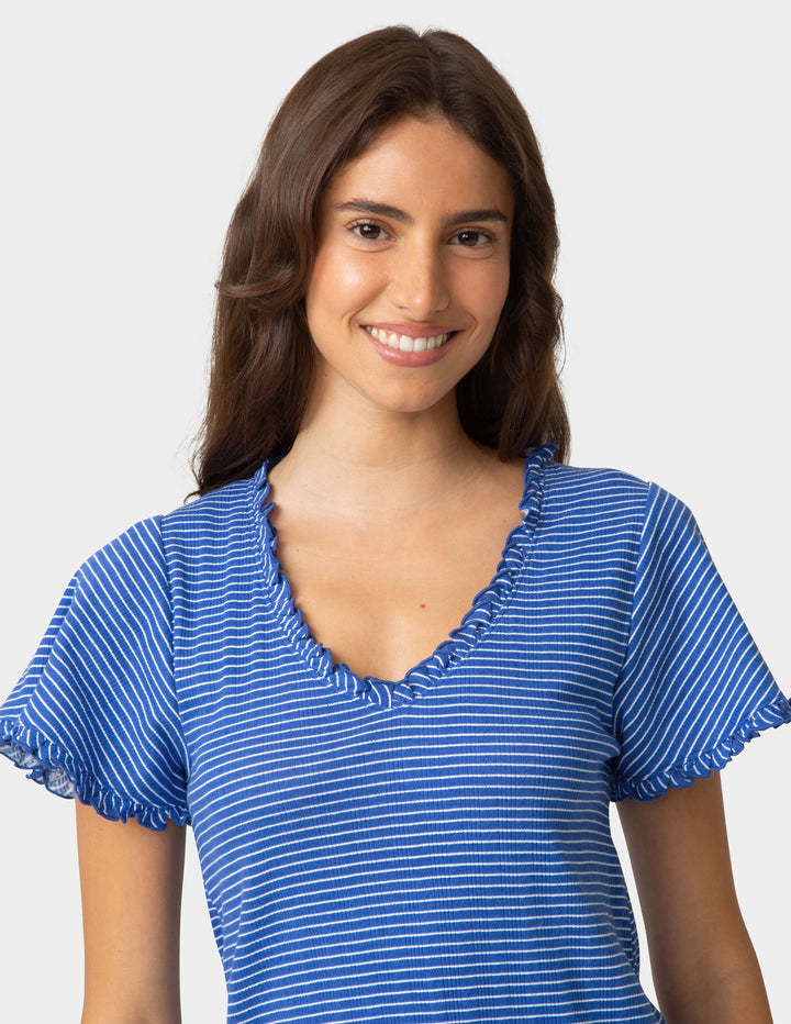 Woman wearing a blue striped pajama tee on a plain background