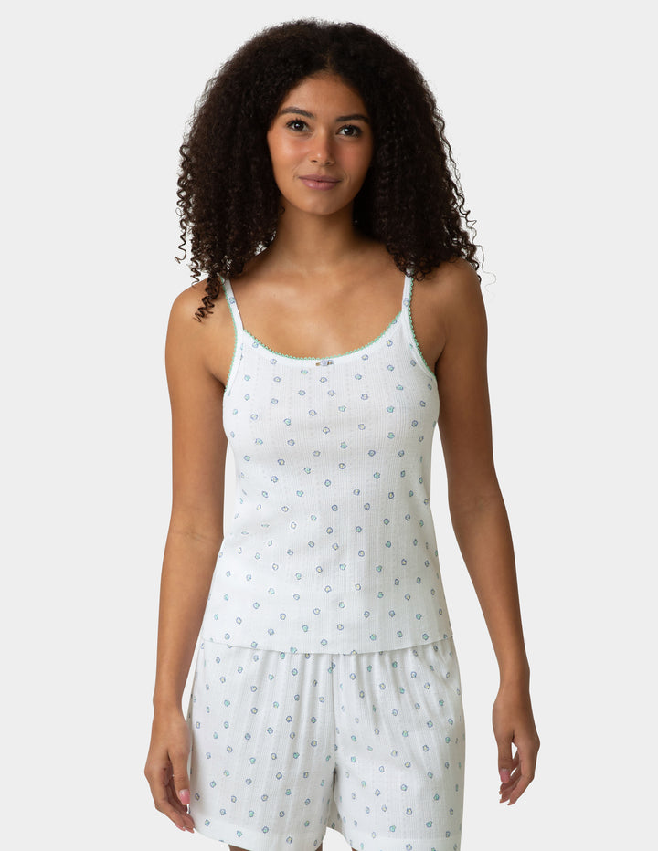 Woman wearing a pj camisole and boxer set with a pattern design on a white background