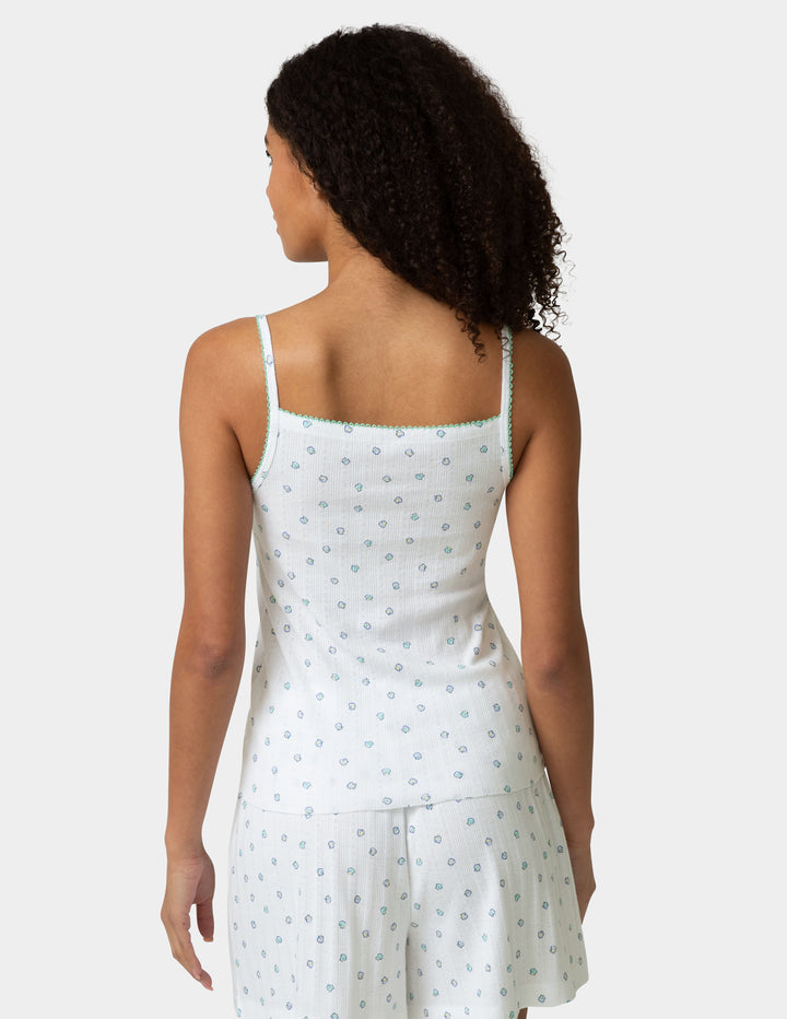 Woman wearing a pj camisole and boxer set with a pattern design on a white background