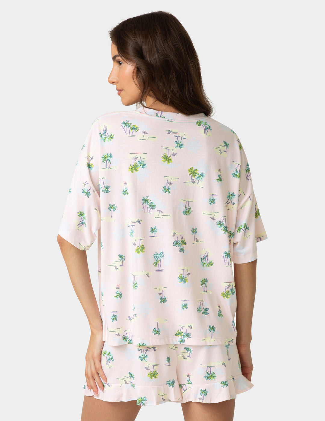 Woman wearing a floral pajama set on a plain background