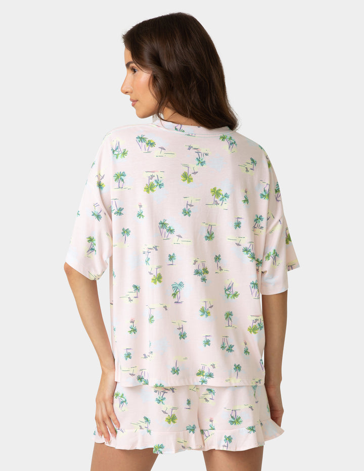 Woman wearing a floral pajama set on a plain background