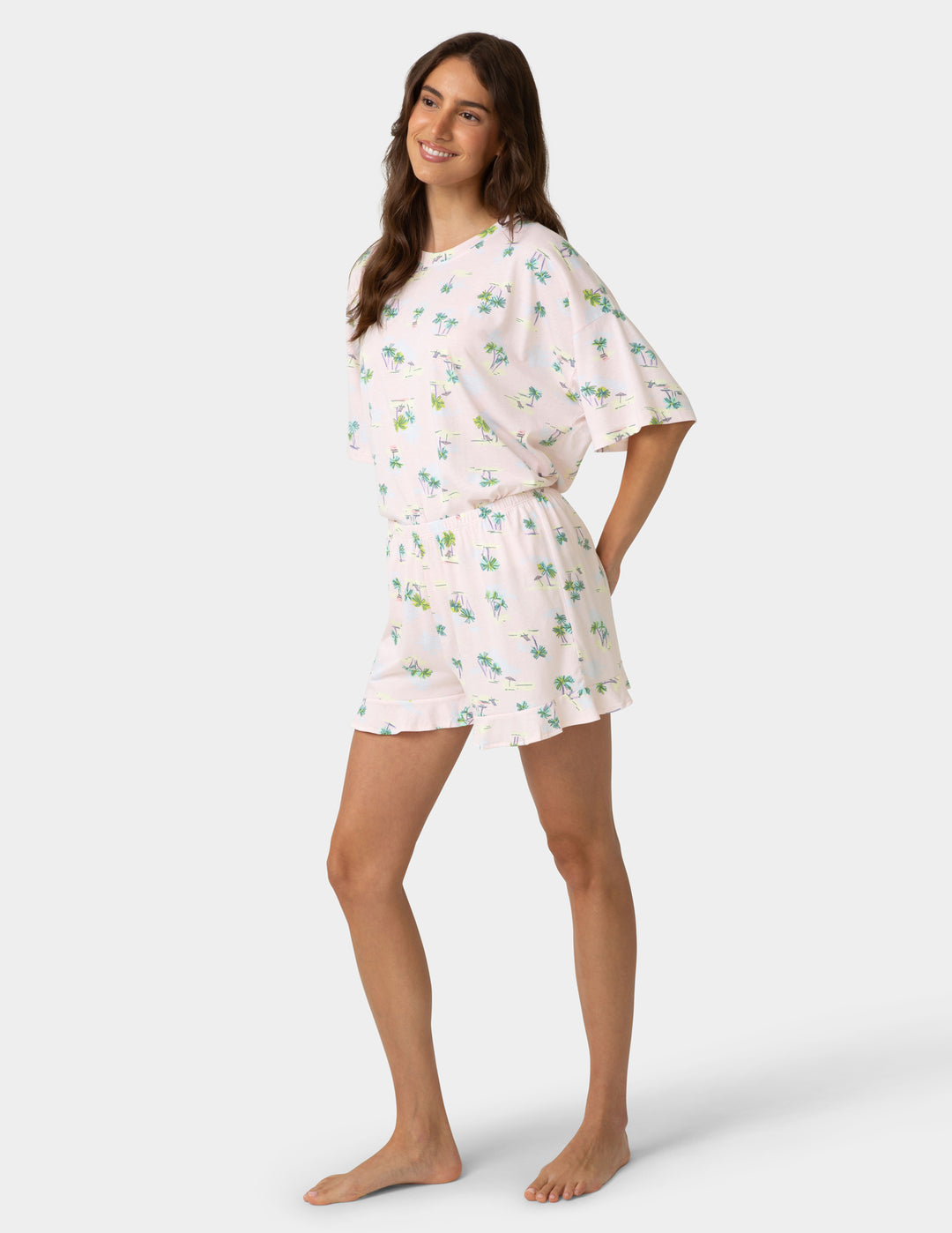 Woman wearing a floral pajama set on a white background