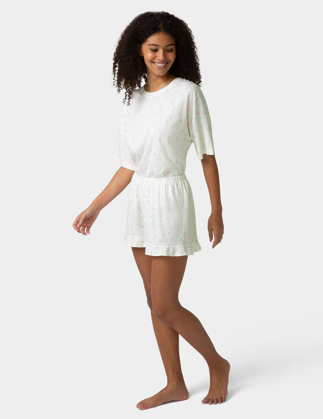 Woman wearing a white pajama set on a plain background