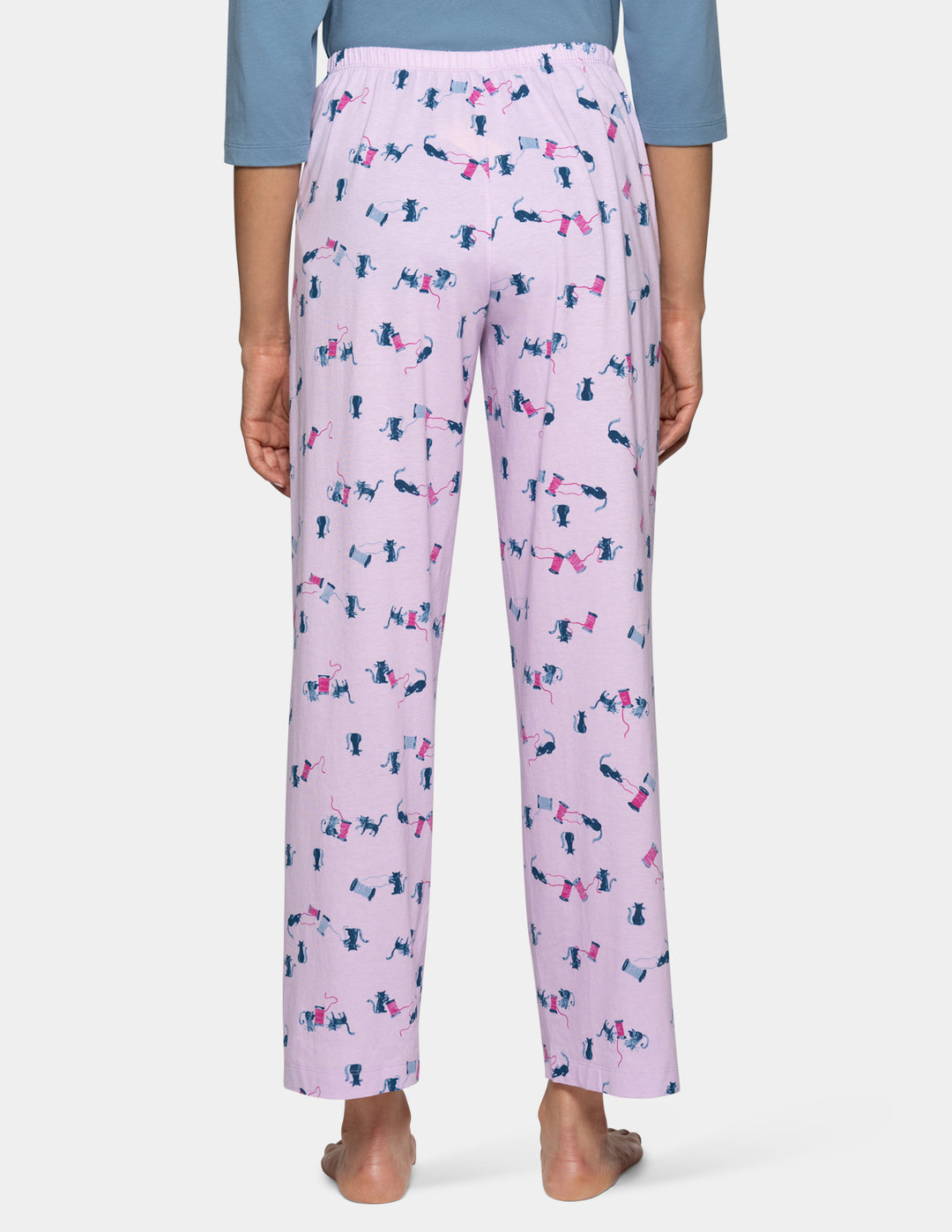 A model shown from the backside view, waist down wearing light purple pajama pants with a cat pattern, paired with a light blue top against a light gray background.