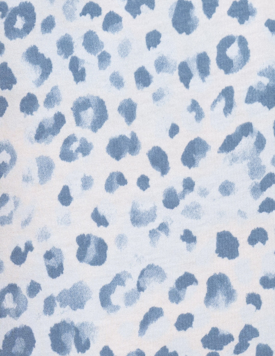 A close-up of a fabric pattern featuring blue leopard spots on a white background.