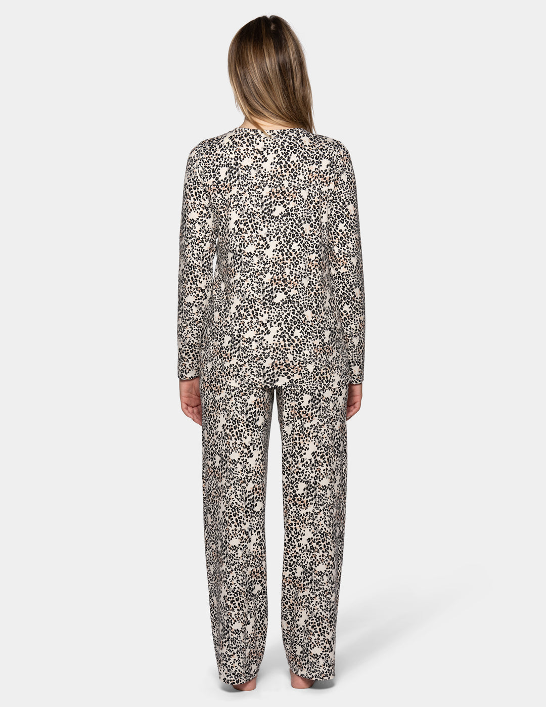 A backside view of model wearing a matching pajama set featuring a long sleeve top and full length pants with an animal print pattern.