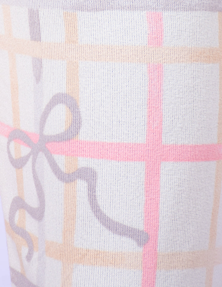 Close-up of a knit fabric with a soft plaid pattern in cream, light pink, and pale peach, featuring a gray ribbon bow motif.