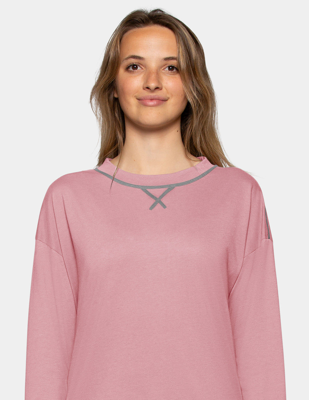 A closeup of a model wearing a pink long sleeve pajama top.