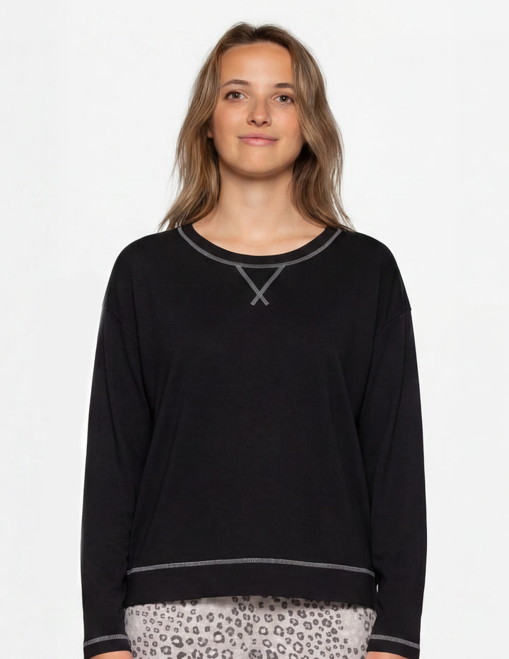 Woman wearing a black long sleeve pajama shirt.