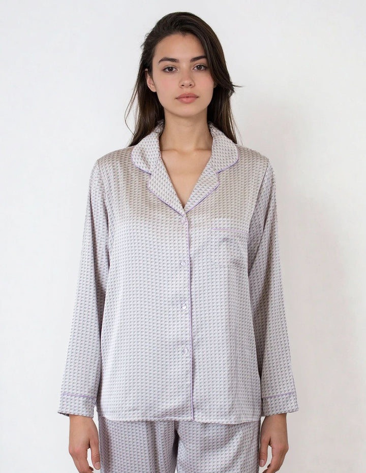 Woman wearing a gray patterned pajama set against a white background