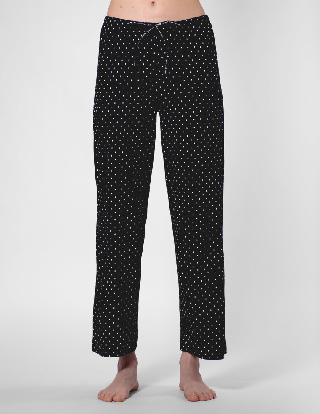Black polka dot pajama pants on a white background
