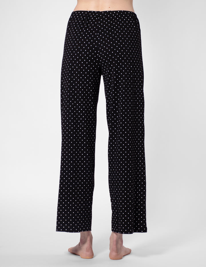 Black pajama pants with white polka dots on a white background
