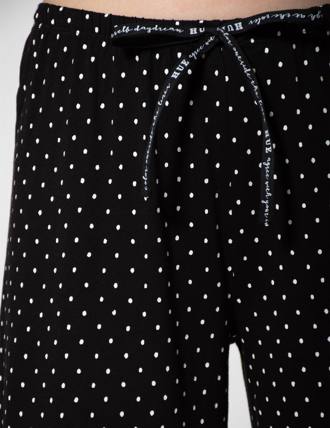 Black polka dot pants with white text on a white background