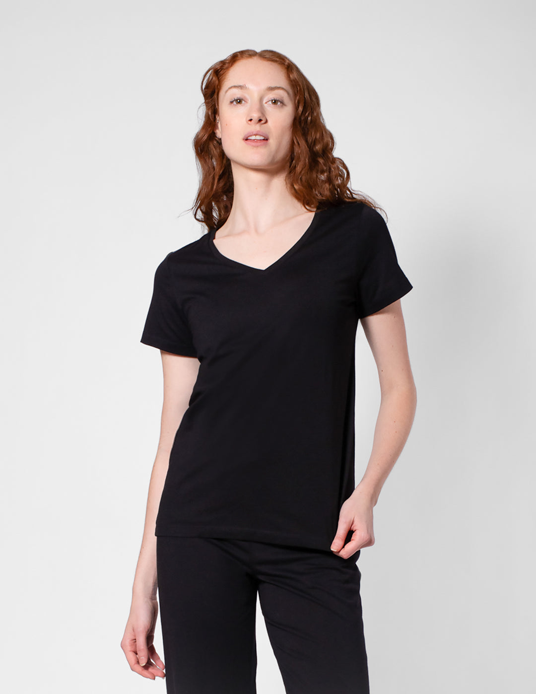 Person wearing a black t-shirt and pants on a white background