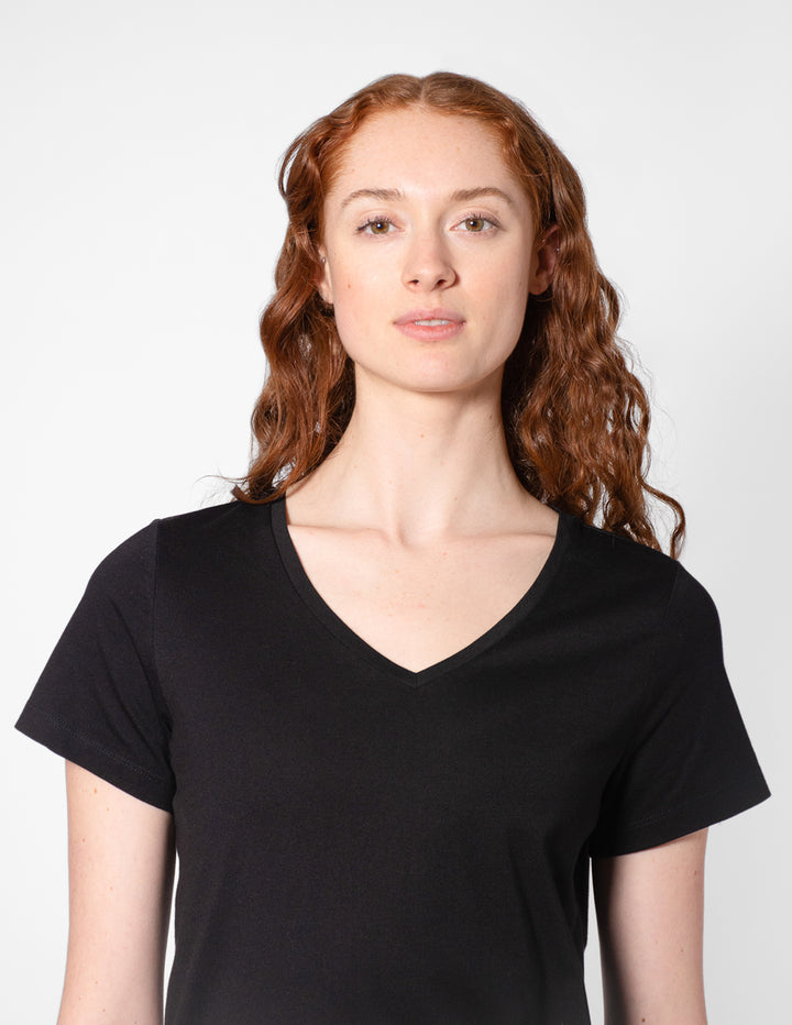 Person wearing a black V-neck t-shirt against a white background