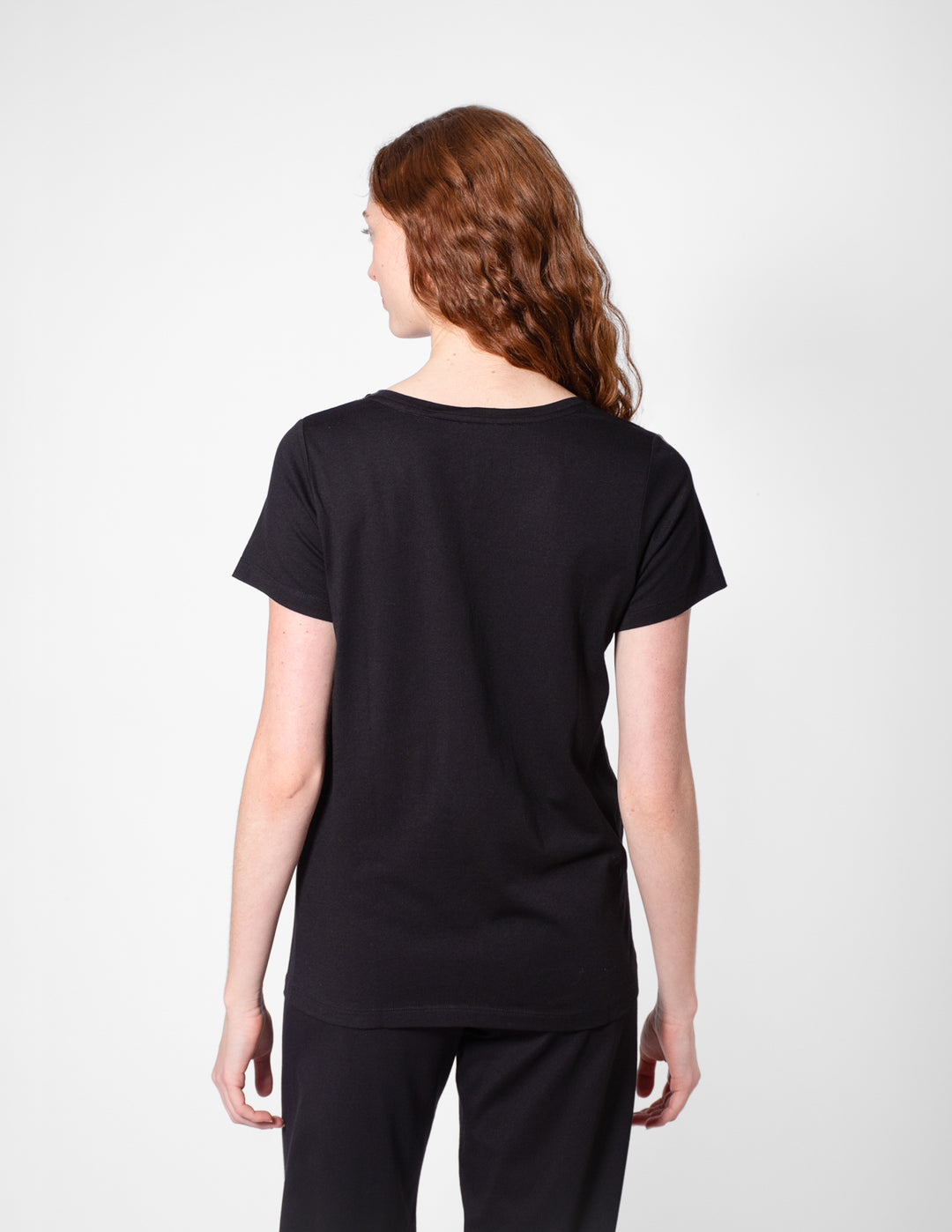 Person wearing a black t-shirt and pants on a white background