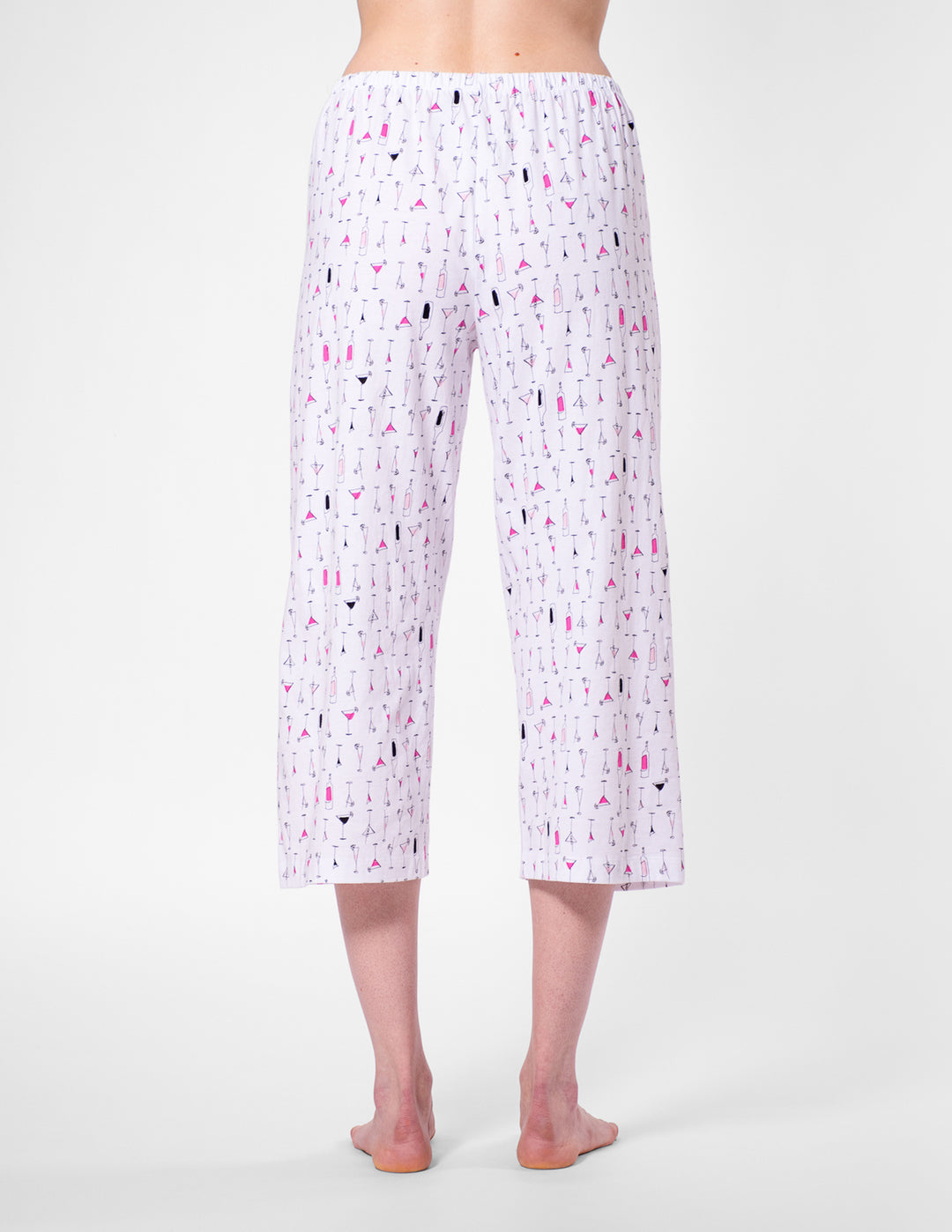 White capri pants with colorful pattern worn by a person on a white background