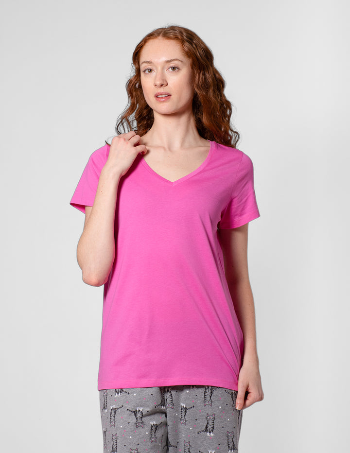 Woman wearing a bright pink t-shirt on a light gray background