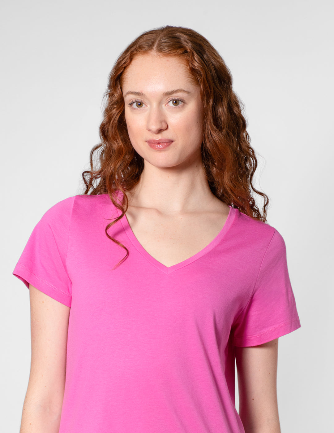 Woman wearing a pink t-shirt against a plain background