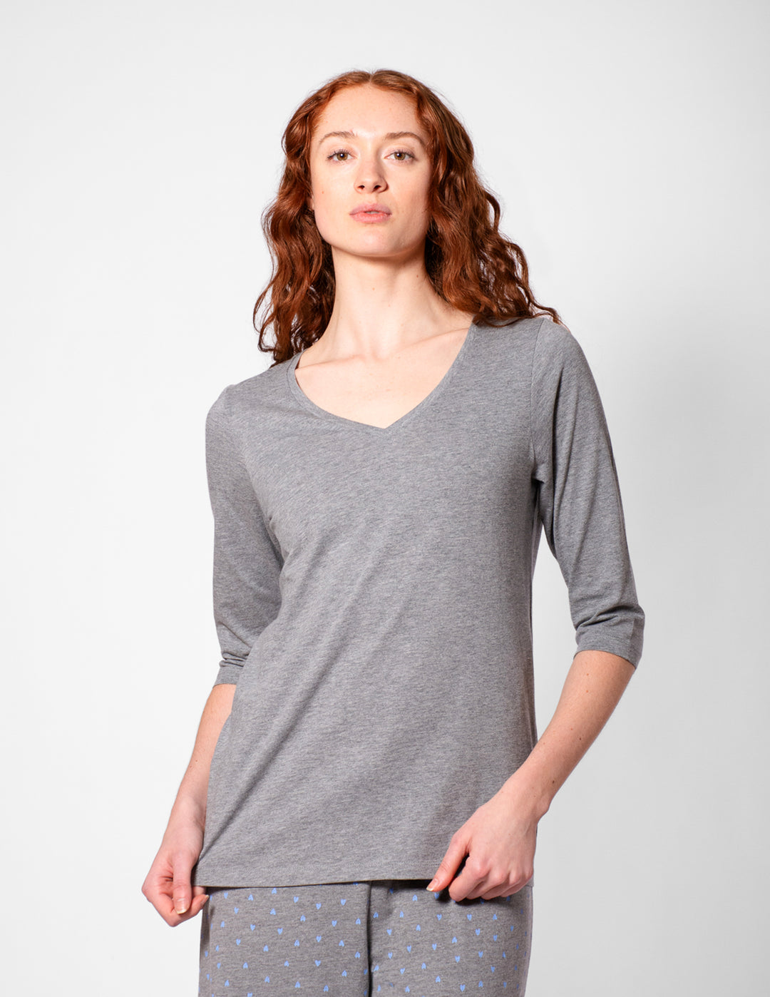 Woman wearing a gray long-sleeve top and pants on a white background