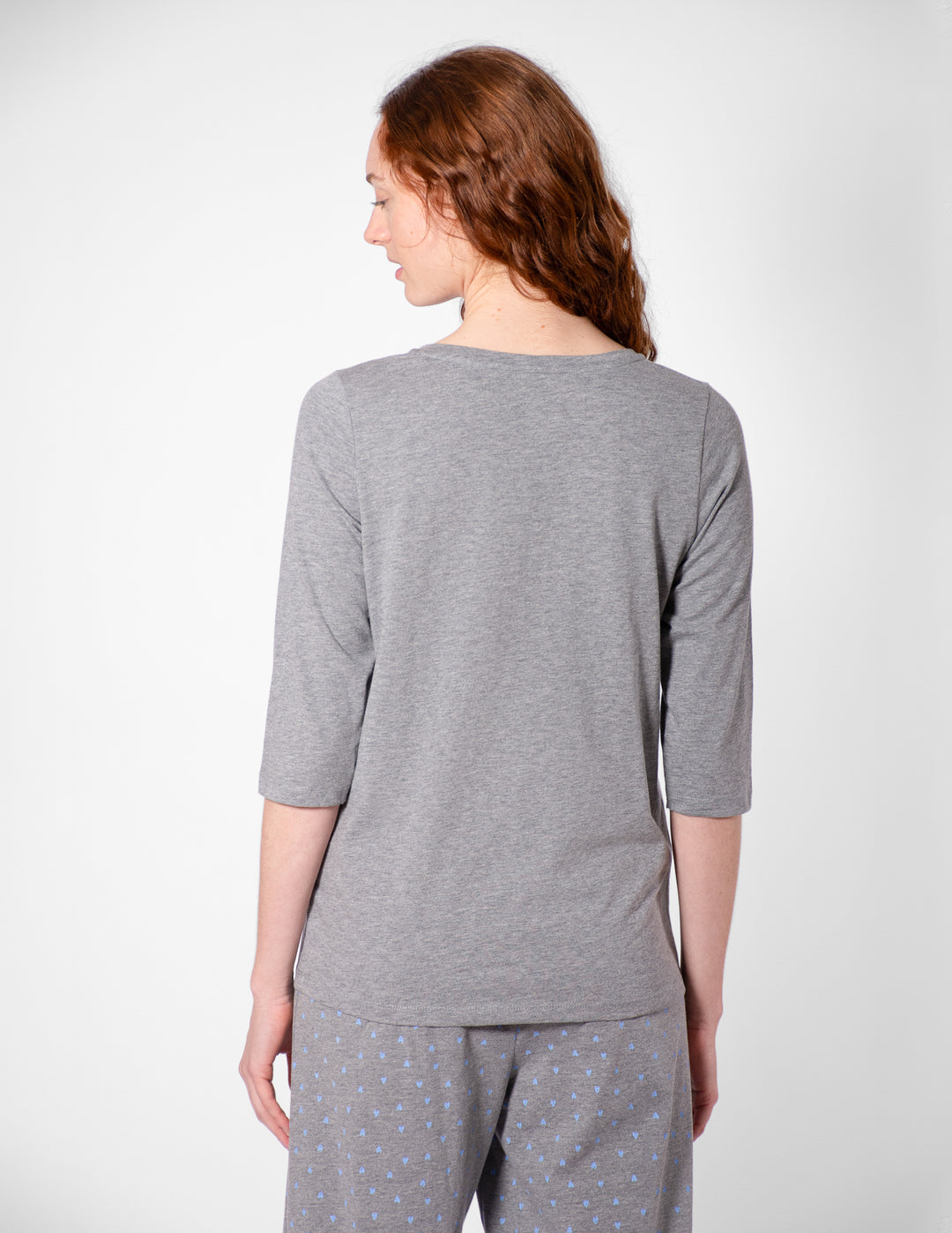Woman wearing a gray pajama set on a white background
