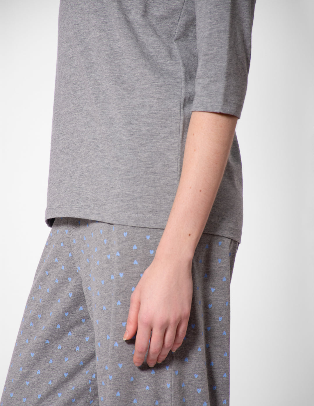 Person wearing a gray outfit with a white background