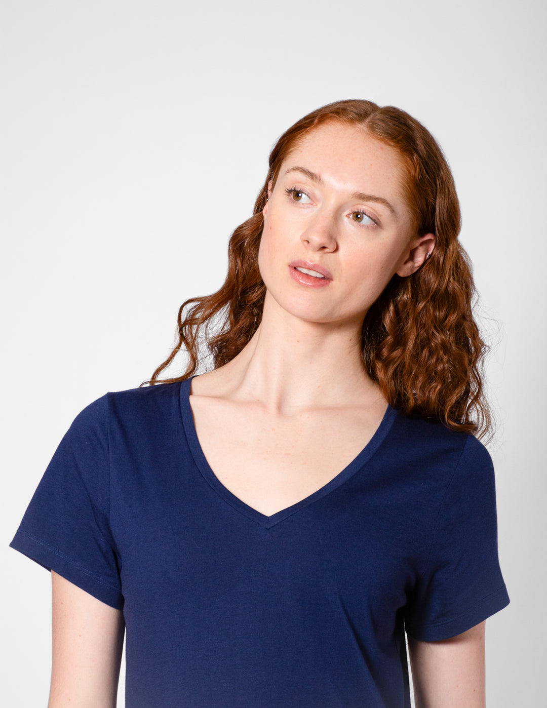Woman wearing a blue V-neck shirt against a white background