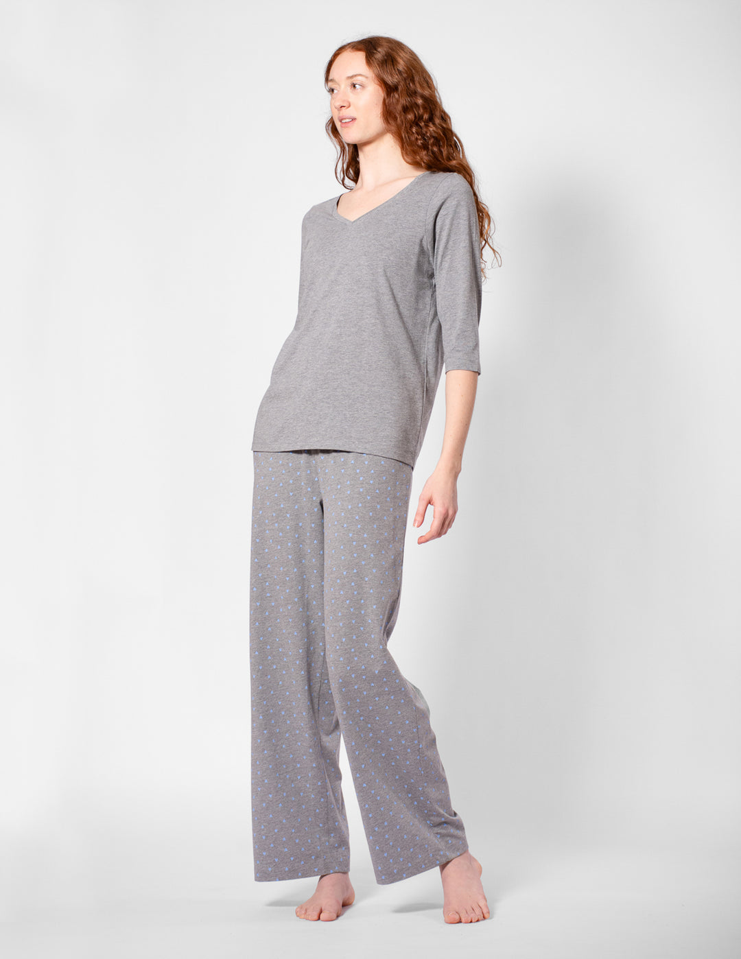 Woman wearing a gray pajama set on a white background