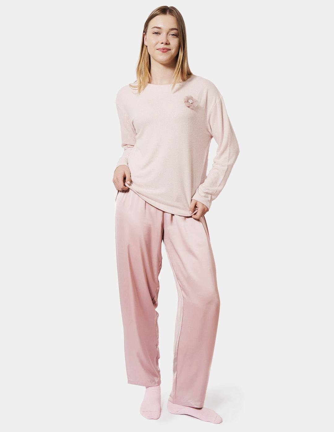 Person wearing a pink pajama set on a white background