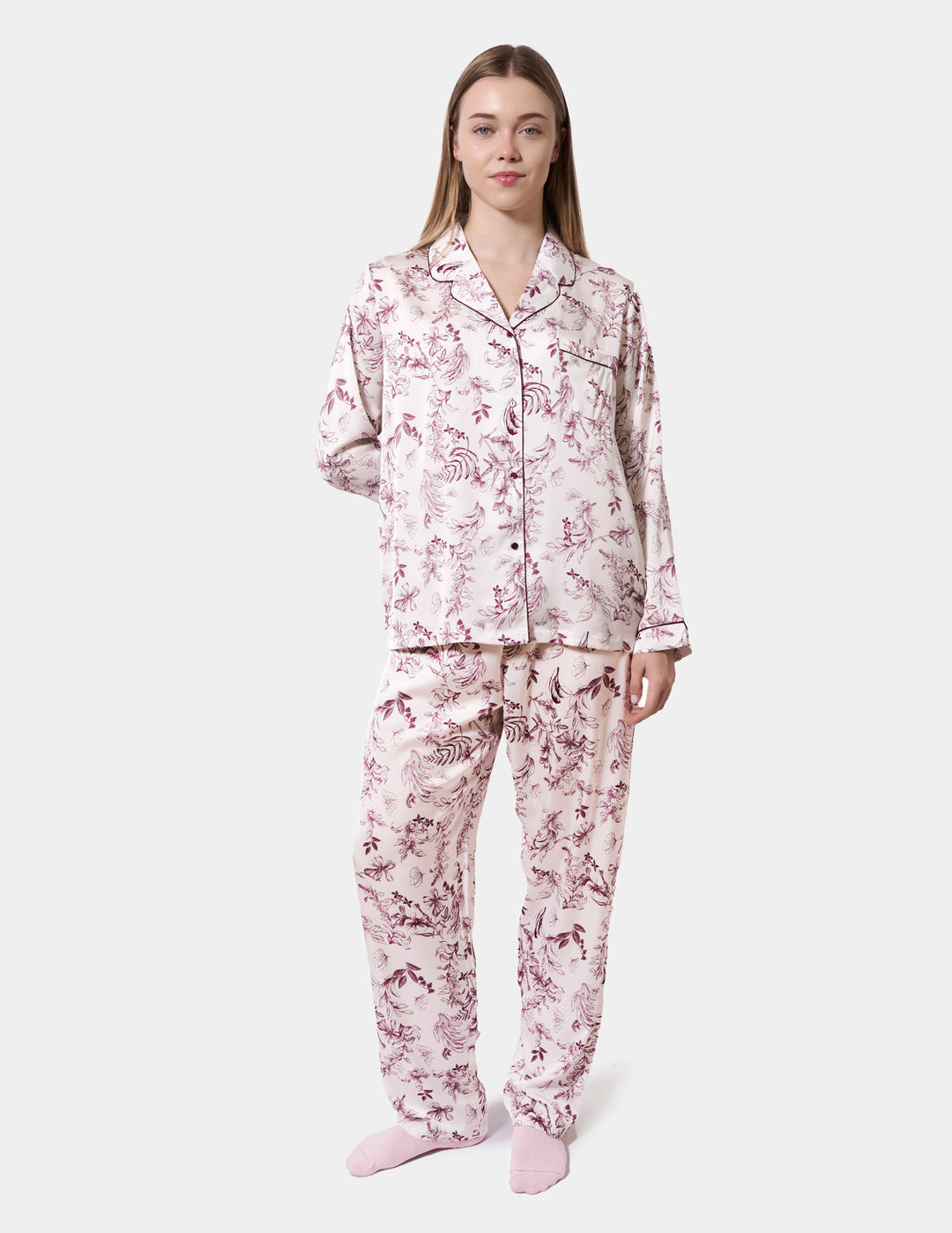Woman wearing a floral pajama set on a white background
