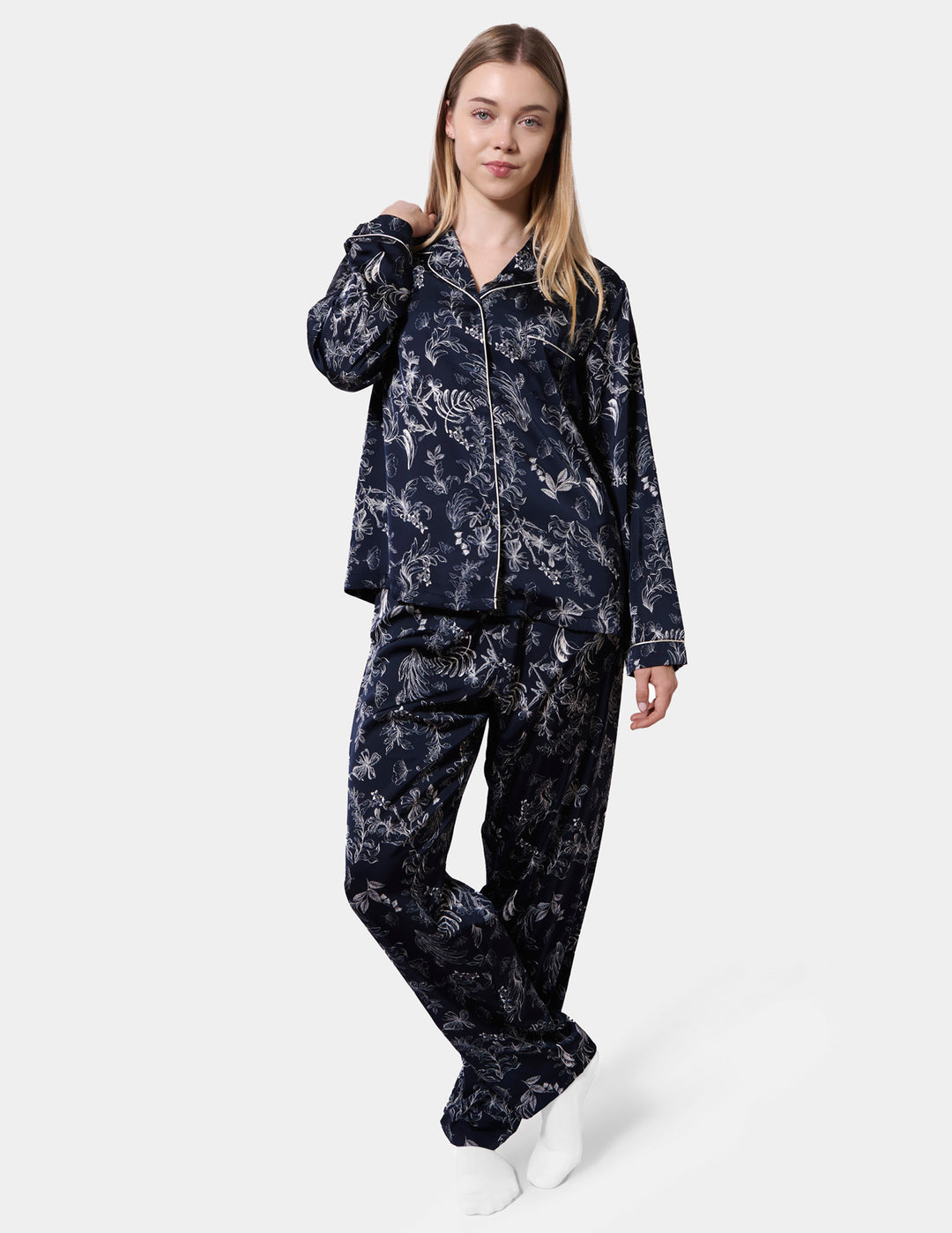 Woman wearing a dark floral pajama set on a white background