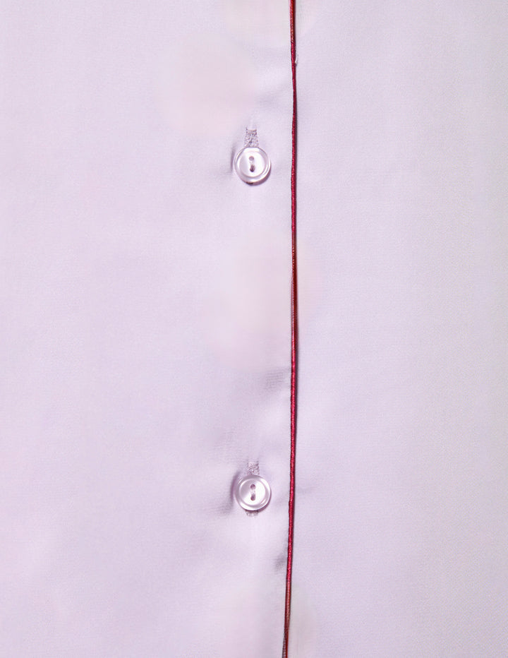 Close-up of a lavender shirt with red trim and buttons