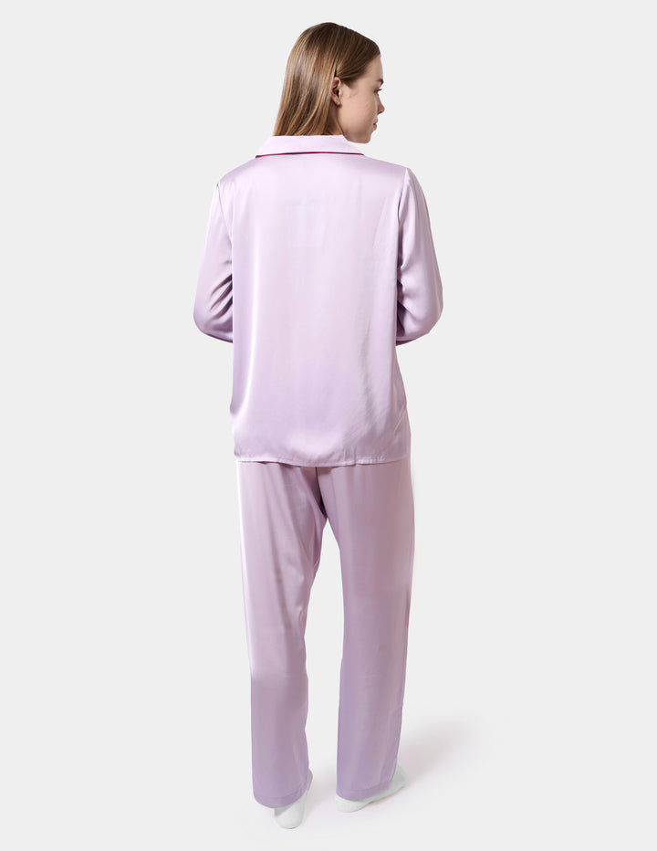 Woman wearing a light purple pajama set on a white background