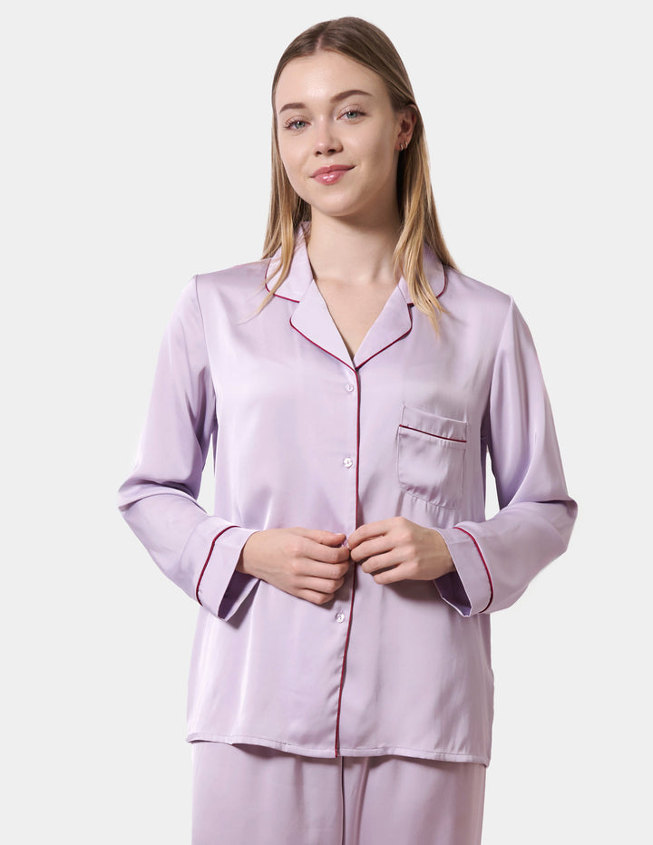 Woman wearing a light purple pajama set on a white background