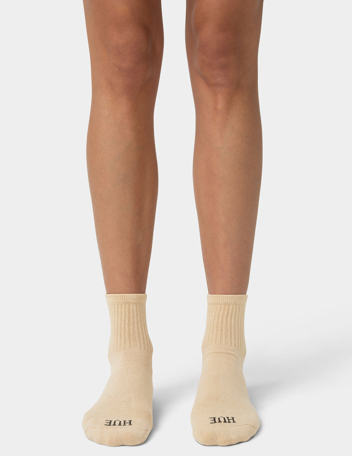 Beige socks worn with tights on a white background